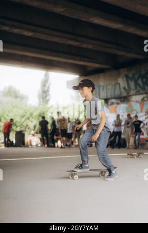 SARAJEVO, BOSNIEN UND HERZEGOWINA - 20. Jun 2021: Ein männliches Kind fährt im Skatepark unter der Brücke in Sarajevo, Bosnien und Herzegowina, Skateboarding Stockfoto