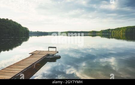 Hölzerner Pier an einem ruhigen See, Polen. Stockfoto