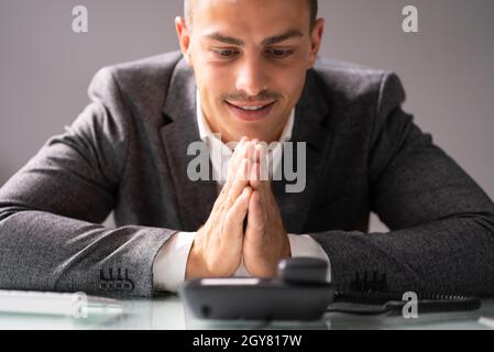 Geschäftsmann Wartet Auf Telefonanruf. Betender Mann Im Büro Stockfoto