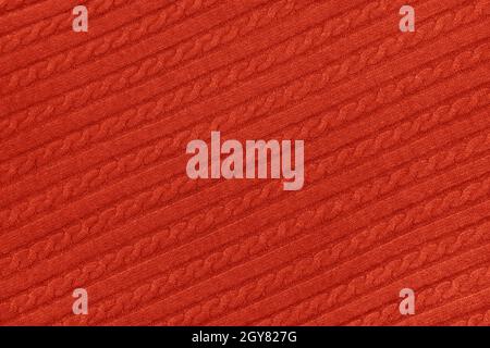 Nahaufnahme der Hintergrundtextur des Pullovers aus rotem, gestricktem Wollstoff mit reihendem Geflecht Stockfoto