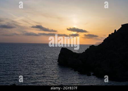 Sonnenuntergang an einem schönen Frühlingstag mit ruhigem Meer, von Anchor Bay, Mellieha, Malta aus gesehen. Stockfoto