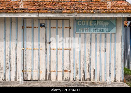 Die Hütten der Austernfischer sind alle farbenfroh mit Streifen verziert und Grenzen an den kleinen Hafen von Audenge, Bassin d'Arcachon, Frankreich Stockfoto