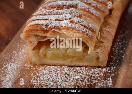 Österreichischer Strudel mit Minze und Puderzucker auf einem Teller. Kuchen mit Apfelmarmelade Stockfoto