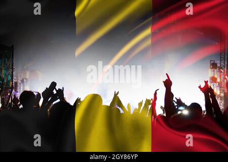 Fußballfans, die Belgien unterstützen - Publikum feiert im Stadion mit erhobenen Händen gegen die belgische Flagge Stockfoto