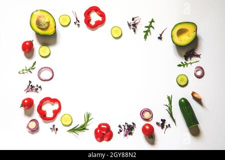 Kreatives Layout von Tomaten, Gurken, Paprika, Avocados und Salaten. Flach legen. Food-Konzept. Platz für Ihren Text. Stockfoto