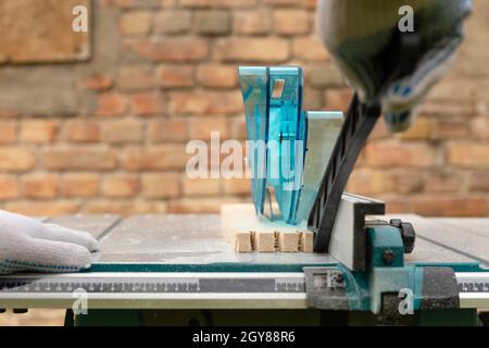 Handlicher Mann, der Holz auf einer Tischsäge schneidet. Zimmerei Holzarbeiten. Stockfoto
