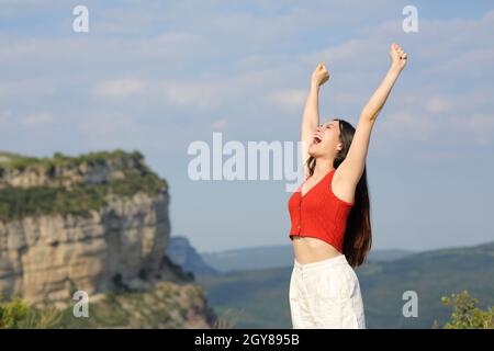 Aufgeregt asiatische Frau feiert heben die Arme in den Berg Stockfoto