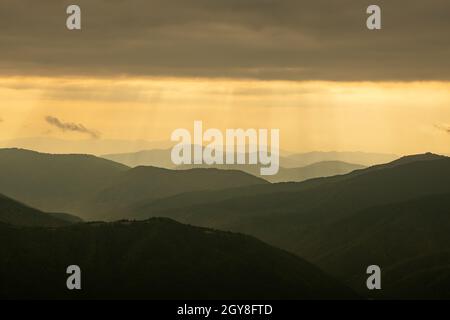Morgensonne in Frühlingsbergen. Wunderschöne Sonnenstrahlen auf dem Hintergrund. Landschaftsfotografie Stockfoto