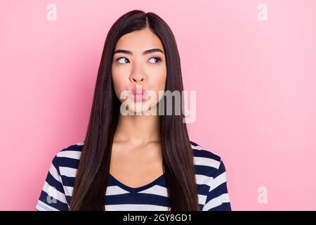 Foto von flirty lange Frisur junge tausendjährige Dame Schlag Kuss leeren Raum tragen gestreiften T-Shirt isoliert auf pastellrosa Hintergrund Stockfoto