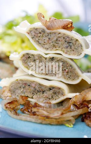 Hälften schwäbische maultaschen Pasta mit Salat Stockfoto