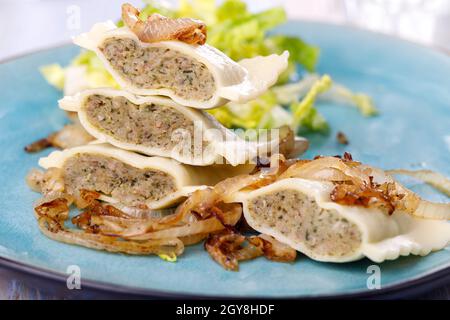 Hälften schwäbische maultaschen Pasta mit Salat Stockfoto