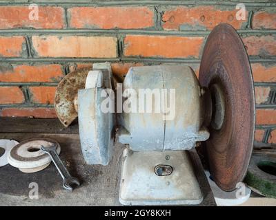 Alte elektrische Schleifer auf der Werkbank in rustikalen Scheune Stockfoto