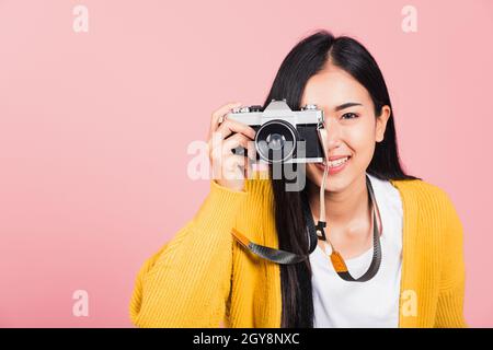 Attraktive energetische glücklich asiatische Porträt schöne junge Frau lächelnd Fotograf Aufnahme eines Bildes und eines Suchers auf einem Retro-Vintage-Foto Ca Stockfoto