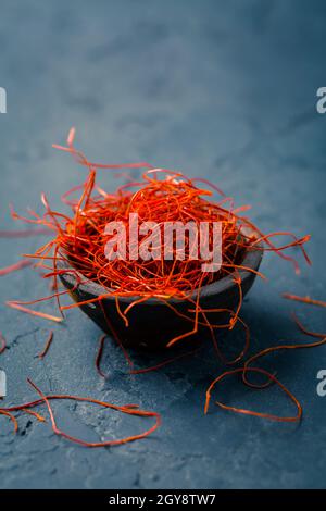 Chili-Fäden in kleiner Schüssel auf dunklem Hintergrund Stockfoto