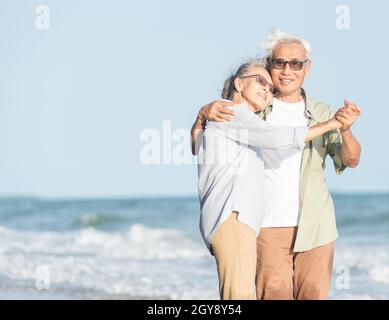 Glückliche asiatische ältere Mann und Frau Paar lächeln tanzen ruhen am Strand entspannen Flitterwochen Familie sonnigen Tag, romantische ältere genießen Reise Sommer vaca Stockfoto