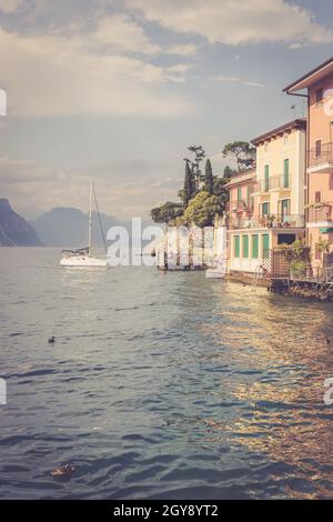 Idyllischer lago di garda int er Abend. Bunt süß italienischen Häuser, Berge und bewölkter Himmel Stockfoto