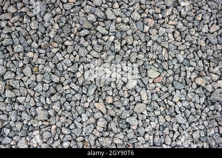 Kleine Steinstruktur oder Kies für Hintergrund oder Design. Dunkelgrau Nahaufnahme kleiner Felsen. Echte Grunge Textur Hintergrund. Graue Kieselsteine mit Steinstruktur. Stockfoto
