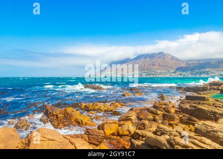 False Bay raue Küstenlandschaft mit Felsbrocken Wellen und Berge mit Wolken in Glencairn Simons Town Kapstadt Westkap Südafrika. Stockfoto