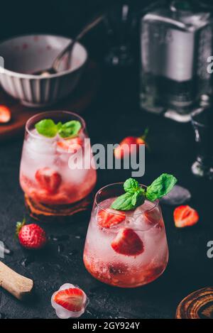 Cocktail mit frischen und gefrorenen Erdbeeren, Gin und Tonic in zwei Gläsern Stockfoto