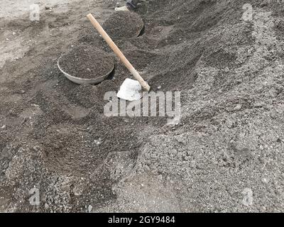 Fawda und Ghamela, Spaten und Tasla liegen auf einem Kieshaufen auf einer Baustelle.A Stockfoto