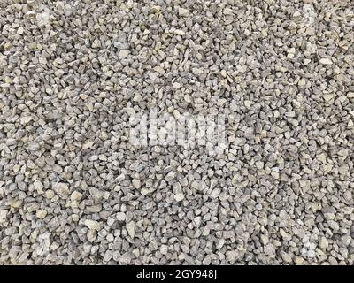 Graue kleine Felsen Boden Textur. Schwarze kleine Straße Stein Hintergrund. Kies Kieselsteine Stein nahtlose Textur, Marmor. Dunkler Hintergrund aus zerkleinerten Granit Stockfoto