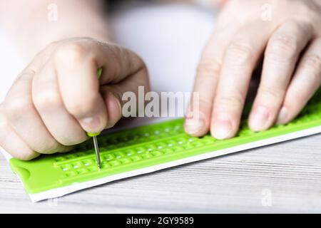 Vorderansicht der Schrift in Braille mit Schiefer und Eingabestift aus der Nähe Stockfoto