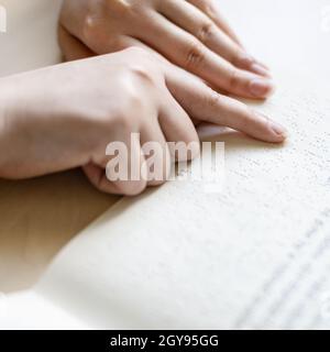 Buch mit Braille-Schrift und üblichem Text aus nächster Nähe lesen Stockfoto