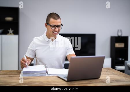 Glücklicher Junger Mann, Der Steuern Und Geldbudget Macht Stockfoto