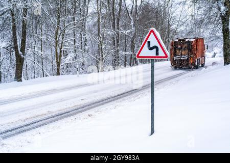 Schwerer Transport auf der kurvigen verschneiten Landstraße Stockfoto