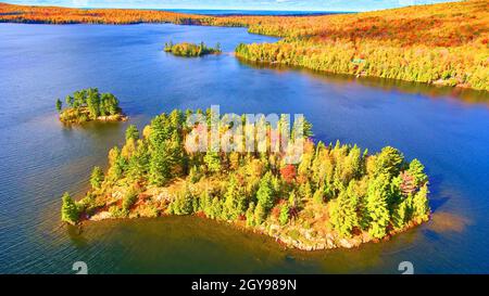 Kleinere Inseln in der Nähe einer größeren Insel von Herbstbäumen in einem großen See mit Lake Michigan weiter weg im Herbst Stockfoto