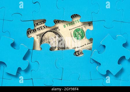 US-Dollar-Währung versteckt unter Puzzle. Finanz- oder Wirtschaftskonzept Stockfoto