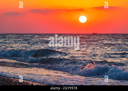 Regenbogenfarben des schönsten Sonnenuntergangs am Strand von Ialysos auf der griechischen Insel Rhodos. Stockfoto