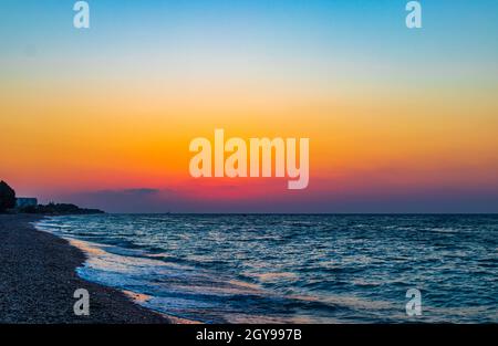 Regenbogenfarben des schönsten Sonnenuntergangs am Strand von Ialysos auf der griechischen Insel Rhodos. Stockfoto