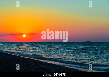 Regenbogenfarben des schönsten Sonnenuntergangs am Strand von Ialysos auf der griechischen Insel Rhodos. Stockfoto