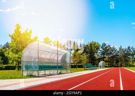 Perspektivische Ansicht eines Freiluftstadions mit roten Laufstrecken, Plastikstühlen, Infrastruktur für sportliche Aktivitäten Stockfoto