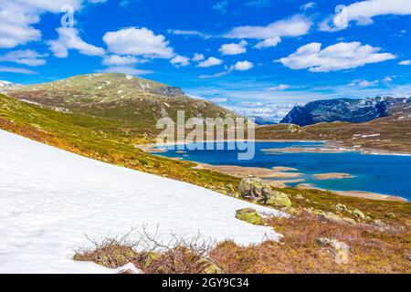 Erstaunliches Vavatn Seenpanorama raue Landschaft Blick Felsen Felsbrocken und Berge mit Schnee im Sommer in Hemsedal Norwegen. Stockfoto