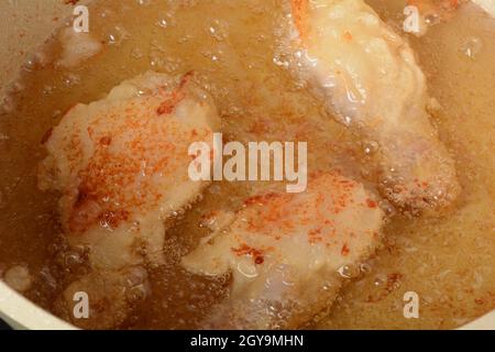 Kochen von Hähnchenschenkeln im Teig. Frittierte Speisen Stockfoto