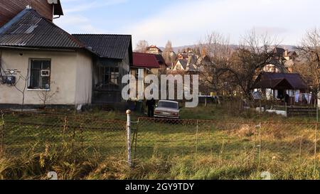 Blick auf die malerischen Dorfhäuser und Ferienhäuser vor der Kulisse der Berge. Die Stadt Yaremche unter den Karpaten im Herbst danach Stockfoto