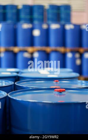 Roter Verschluss auf blauen Chemiefässern. Viele Fässer stehen im Hintergrund an. Stockfoto