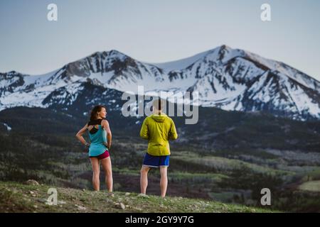 Zwei Freunde atmen beim Rennen vor dem großen Gipfel durch Stockfoto