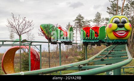 Ukraine, Kiew - 24. Oktober 2019: Achterbahn Art Attraktion. Die Achterbahn in Caterpillar-Form befindet sich in einem Vergnügungspark. Karussells und Freizeit Stockfoto