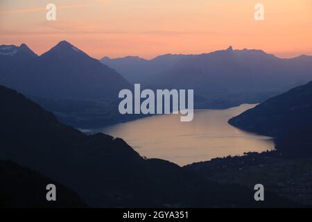 Roter Abendhimmel über dem Thunersee und den Bergketten in der Schweiz. Stockfoto