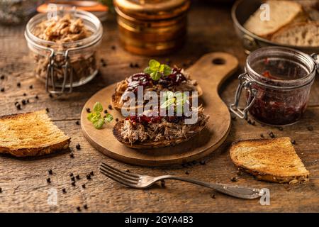 Gezogene Ente mit karamellisierten Zwiebeln auf rustikalem Hintergrund Stockfoto