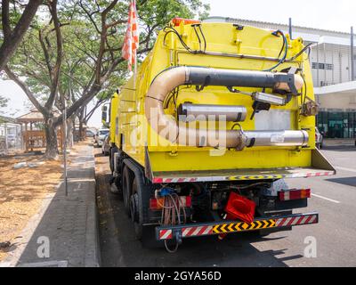 Ein Auto für die Reinigung von Straßen mit runden Bürsten auf einer Stadtstraße. Stockfoto