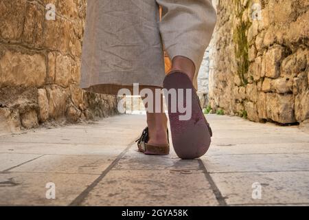 Detail Aufnahme der weiblichen Beine tragen bequeme Reise Sandalen Spaziergang auf alten mittelalterlichen Kopfsteinpflaster Straße dring Sightseeing City Tour. Reisen, Tourismus Stockfoto