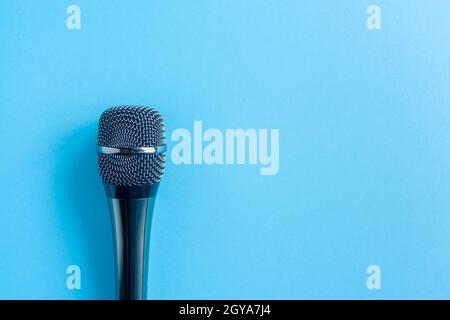 Mikrofon auf farbigem blauem Hintergrund in Nahaufnahme. Singen, Musik schreiben, Karaoke online, Kreativität, Vocals Konzept, Symbol. Gesangsunterricht Stockfoto