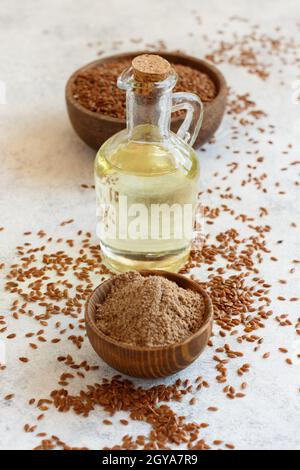 Rohe Leinsamen Mehl, Öl und Samen mit einem Löffel schließen sich auf den weißen Tisch Stockfoto