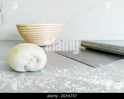 Vorderansicht von Teig, Gärkorb und Metallmesser für Teig Stockfoto