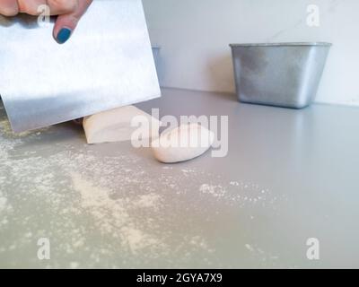 Der Bäcker schneidet den Teig in kleine Stücke Stockfoto