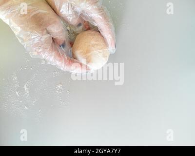 Der Koch in Handschuhen arbeitet mit dem Teig, der Ansicht von oben Stockfoto